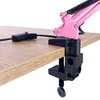 A close-up view of a pink desk lamp's clamp and switch attached to a wooden desk. Anteprima dell’immagine prodotto