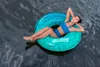 A woman relaxing on an inflatable tube in the water. Anteprima dell’immagine prodotto