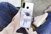 A person holding a phone with a flower case while sitting down. Produktbild-Vorschau