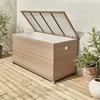 An outdoor storage box made of rattan is shown on a wooden deck next to a brick wall. Anteprima dell’immagine prodotto