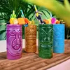 Four tiki mugs with fruit garnishes and straws are arranged on a wooden surface with tropical plants in the background. Podgląd zdjęcia produktu