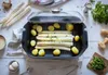 A cooking pot with white asparagus and potatoes inside, surrounded by ingredients. Produktbild-Vorschau