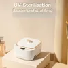A small, white sterilization box with gold trim sits on a beige pedestal. A perfume bottle is visible to the left. Text about UV sterilization is present at the top. Produktbild-Vorschau
