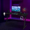 A gaming desk setup in a room with purple neon lighting. Produktbild-Vorschau