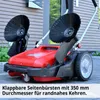 A red manual sweeper with two large brushes is shown outdoors on a paved surface, with a building in the background. Produktbild-Vorschau