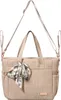 A beige diaper bag with a patterned scarf tied to the front. Produktbild-Vorschau