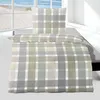 A plaid patterned duvet cover and pillowcase set on a bed, with a window view of a beach in the background. Produktbild-Vorschau