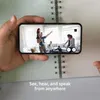 A hand holding a smartphone displaying a family inside a home, with text overlay. Produktbild-Vorschau