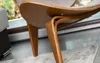 Close-up of the wooden legs and underside of a designer armchair. Voir les images du produit