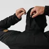 A person adjusting the hood of a black jacket. Náhled obrázku produktu