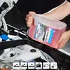 A person is pouring pink liquid from a large plastic container into the engine bay of a car. Produktbild-Vorschau