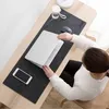 A person using a laptop and mouse on a desk mat. Produktbild-Vorschau