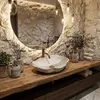 A bathroom vanity with a stone vessel sink and a wooden countertop. Anteprima dell’immagine prodotto