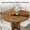 A round wooden dining table with a floral arrangement and fruit bowl on it, set in a dining room with chairs. Voir les images du produit