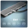 A close-up product shot of a silver USB-C hub with a connected cable, set against a gradient blue and gray background. Icons representing features are displayed below. Produktbild-Vorschau