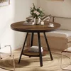 A round dining table with a wooden top and black metal legs, set in a cozy dining area with chairs and a bench. Produktbild-Vorschau