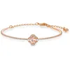A rose gold bracelet with a clover-shaped centerpiece featuring a pink stone and small white stones, set against a white background. Anteprima dell’immagine prodotto