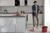 A man is mopping the floor in a modern kitchen. Náhled obrázku produktu
