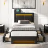 A modern bedroom setup featuring a black upholstered bed with LED lighting, nightstands, and a large framed artwork on the wall. Podgląd zdjęcia produktu