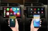 A split image showing a car's infotainment system with an iPhone connected via CarPlay on the left and an Android phone connected via Android Auto on the right. Produktbild-Vorschau