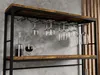 A wine rack with glasses and a decanter on a shelf, against a textured wall. Podgląd zdjęcia produktu