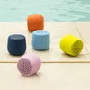 Several colorful Bluetooth speakers are placed on a tiled surface next to a swimming pool. Náhľad obrázku produktu