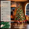 A decorated Christmas tree in a cozy living room setting with a fireplace and gifts. Náhled obrázku produktu