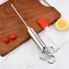 A stainless steel meat injector, two cherry tomatoes, a silicone basting brush, and a lemon slice are arranged on a wooden cutting board and a marble-patterned surface. Voir les images du produit