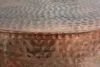 A close-up view of the hammered metal surface of a round table. Produktbild-Vorschau