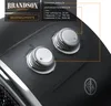 A close-up view of the control panel of a black heater, showing two silver rotary dials and text labels indicating functions and settings. Produktbild-Vorschau