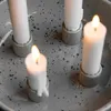 A close-up shot of four white candles in small gray holders, placed on a speckled gray tray. Produktbild-Vorschau