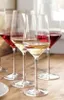 Several wine glasses filled with red and white wine on a wooden table. Anteprima dell’immagine prodotto