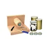 A set of items for making tin can lanterns, including a wooden hammering device, nails, a hammer, tin cans, and tea lights. Produktbild-Vorschau