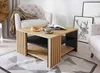 A coffee table is shown in a living room setting with a chair and a sofa. Voir les images du produit