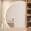 A modern bathroom setting with a large circular mirror reflecting a bathtub and faucet. Produktbild-Vorschau