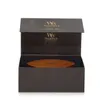An open gift box containing a WoodWick candle lid. Podgląd zdjęcia produktu