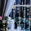 Christmas decorations hanging in a window with lights and a Christmas tree. Náhľad obrázku produktu