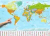 A hand is pointing to South America on a world map poster. The poster is colorful and detailed, showing continents, oceans, and countries. There are also small flags of various countries at the bottom of the poster. Podgląd zdjęcia produktu