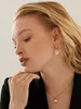 Close-up of a woman wearing gold earrings and a necklace. Anteprima dell’immagine prodotto