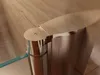 A close-up view of a shower door hinge and frame, with a marble-patterned wall in the background. Produktbild-Vorschau