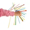 A hand holding a bundle of colorful sticks, likely a game. Náhled obrázku produktu