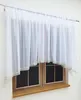 A white sheer curtain is draped over a wooden window frame. Produktbild-Vorschau
