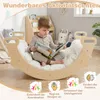 A child is reading a book while sitting on a wooden rocking arch in a room. Náhľad obrázku produktu