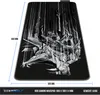 A large gaming mousepad with a black background and a detailed, abstract graphic design in shades of gray and white. Dimensions and weight are indicated with text and lines. Produktbild-Vorschau
