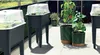 Several raised garden beds and planters are arranged on a patio, with some containing plants and others covered with clear lids. Produktbild-Vorschau