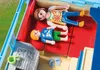 Two Playmobil figures are lying on the red seats of a caravan. Produktbild-Vorschau
