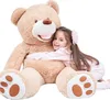 A young girl hugging a large teddy bear. Podgląd zdjęcia produktu
