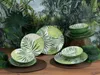 A collection of tropical-themed dinnerware set against a lush jungle backdrop. Náhľad obrázku produktu