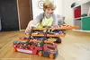 A young boy is playing with a Hot Wheels Mega-Truck filled with toy cars. Náhled obrázku produktu
