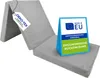 A folded gray mattress with labels indicating certifications and origin. Podgląd zdjęcia produktu